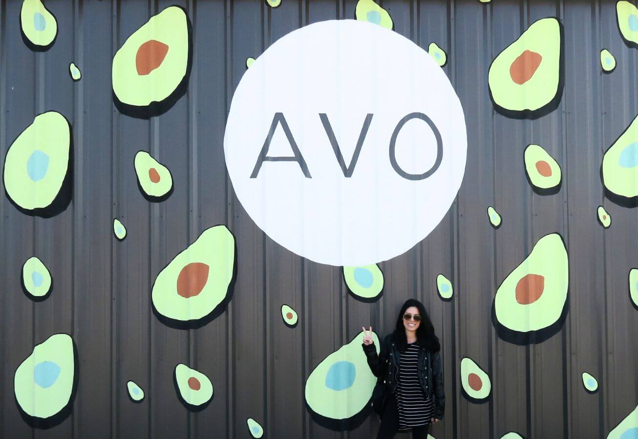 Marissa posing in front of AVO avocado mural